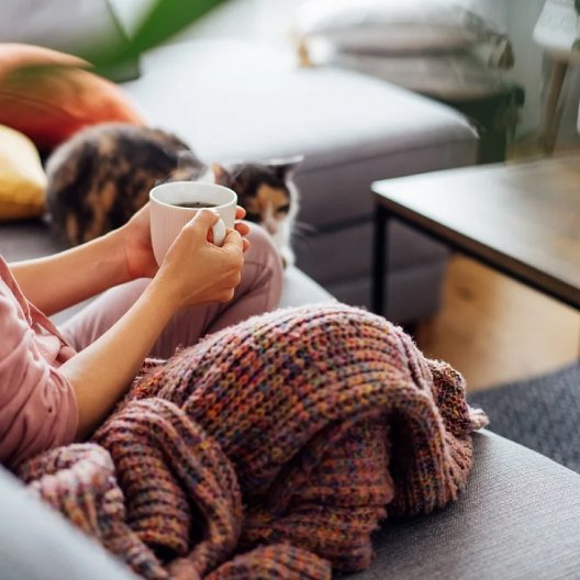 Woman sitting on the couch drinking a coffee