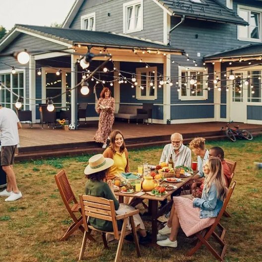 Family gathered around summer BBQ with wooden furniture